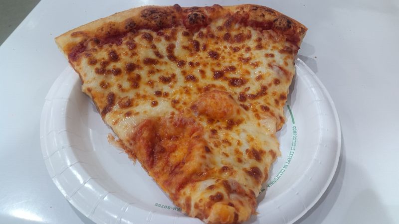 Photo of a cheese pizza on a paper late.